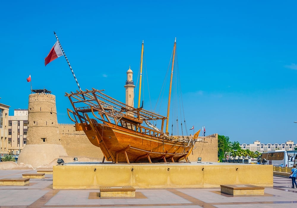 An old wooden dhow in front of the Al Fahidi Fort